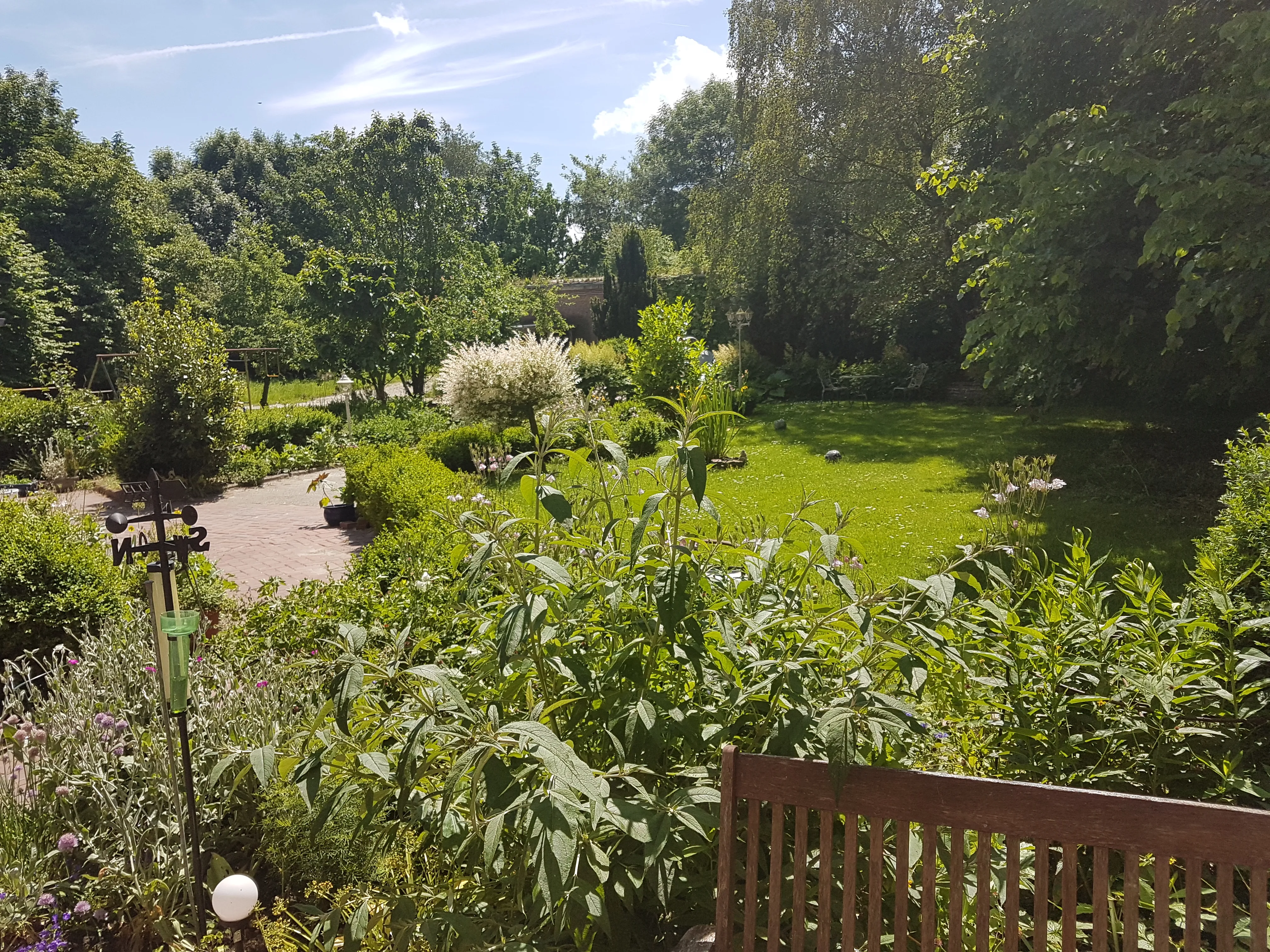 Garten mit Spielplatz, im Hintergrund frei laufende Hühner