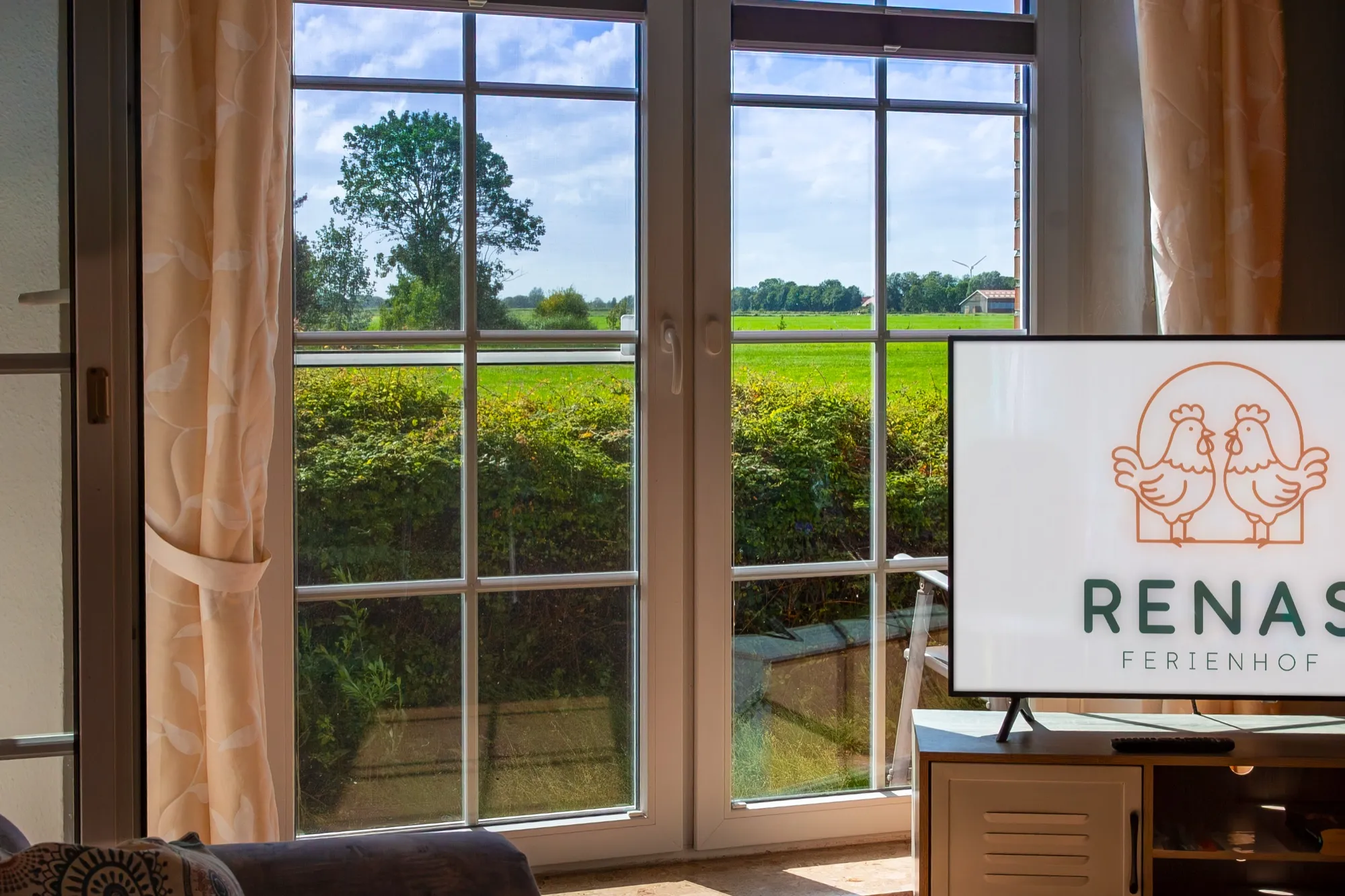 Blick durchs Wohnzimmerfenster über die Felder