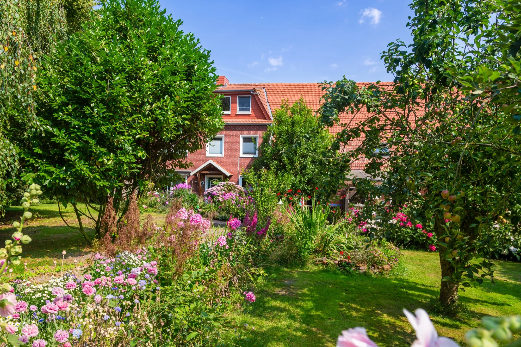 Blühender Garten vor dem Haupthaus mit der Ferienwohnung Up'n Warf